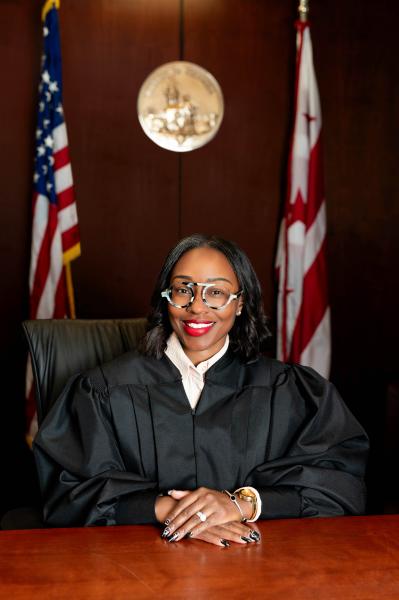 The Acting Chief Administrative Law Judge, a black women wearing large glasses, smiling and posing